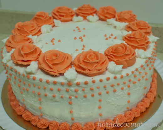 Tarta glaseada con buttercream, con corona de rosas naranjas de glasa real
